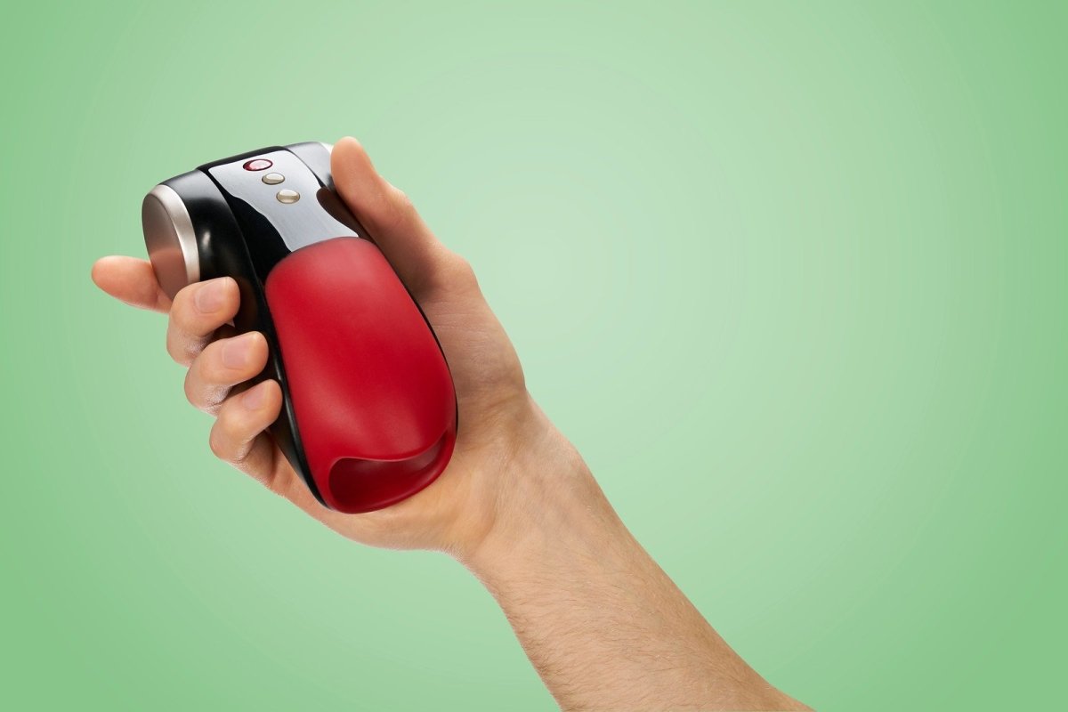 Hand holding a red, silver and black Cobra Libre 2 against a green background.