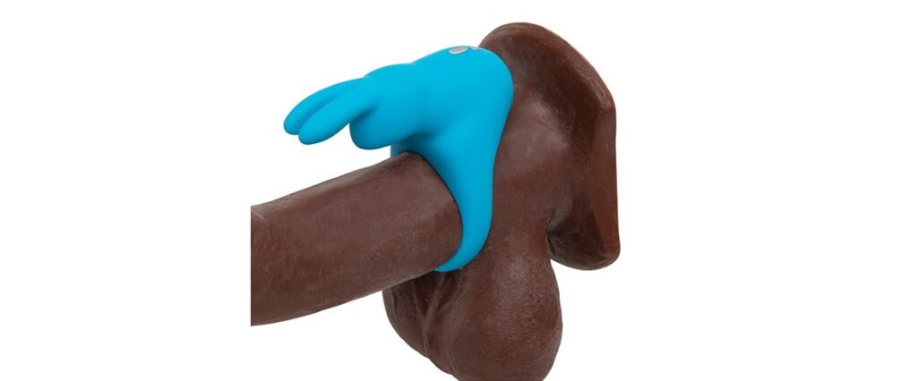 The Happy Rabbit Rechargeable Cock Ring in Blue wrapped around the base of a dildo, showcasing how the rabbit and its rabbit ear clitoral arms will surround the clit. | Kinkly Shop
