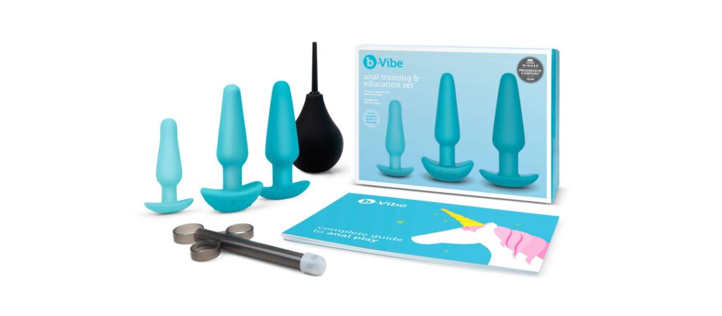 Everything that's included within the b-Vibe Anal Training Kit against a white background. The image shows the small plug, the medium plug, the large plug, the enema bulb, the lube shooter, and the full-color educational booklet. Plus the packaging! | Kinkly Shop