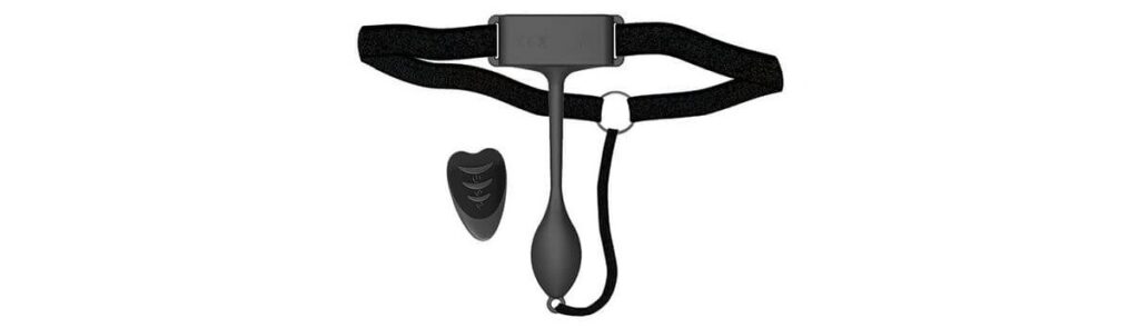 The Adrien Lastic Pan-T Vibrator shown against a white background with the vibrator and harness laid out like how they'd be worn when wrapped around someone's hips. | Kinkly Shop