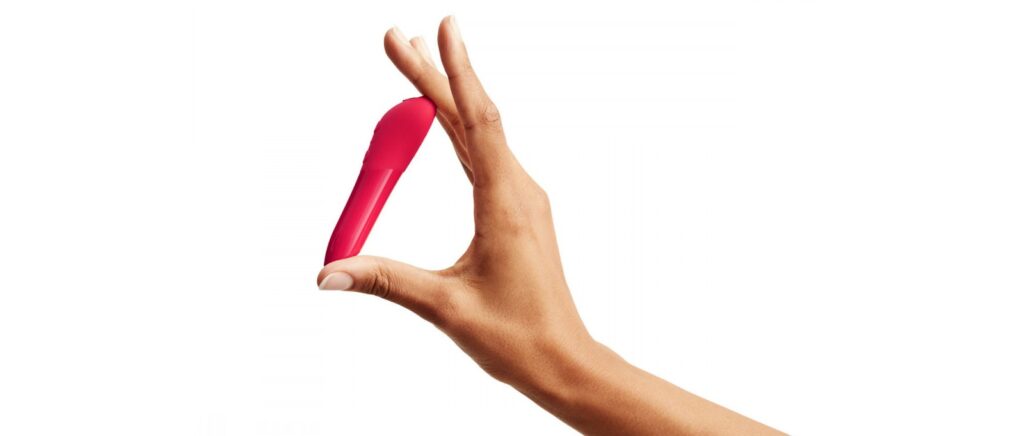 A hand holding the We-Vibe Tango X to show the small size of the pink bullet vibrator | Kinkly Shop